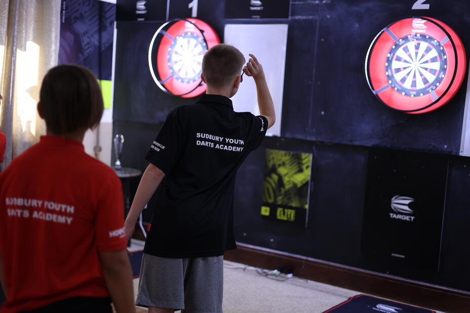Sudbury Youth Darts Academy youth player throwing darts at a dartboard