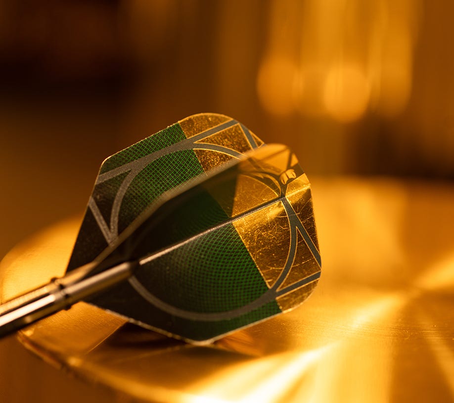 Close-up view of the Cult Envy edition No.6 dart flight with a luxurious metallic gold finish.