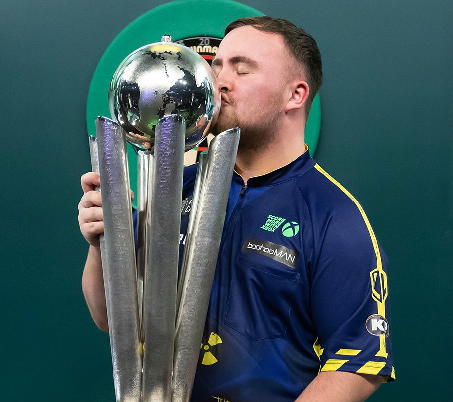 Luke Littler kissing the 2025 World Darts Championship Trophy
